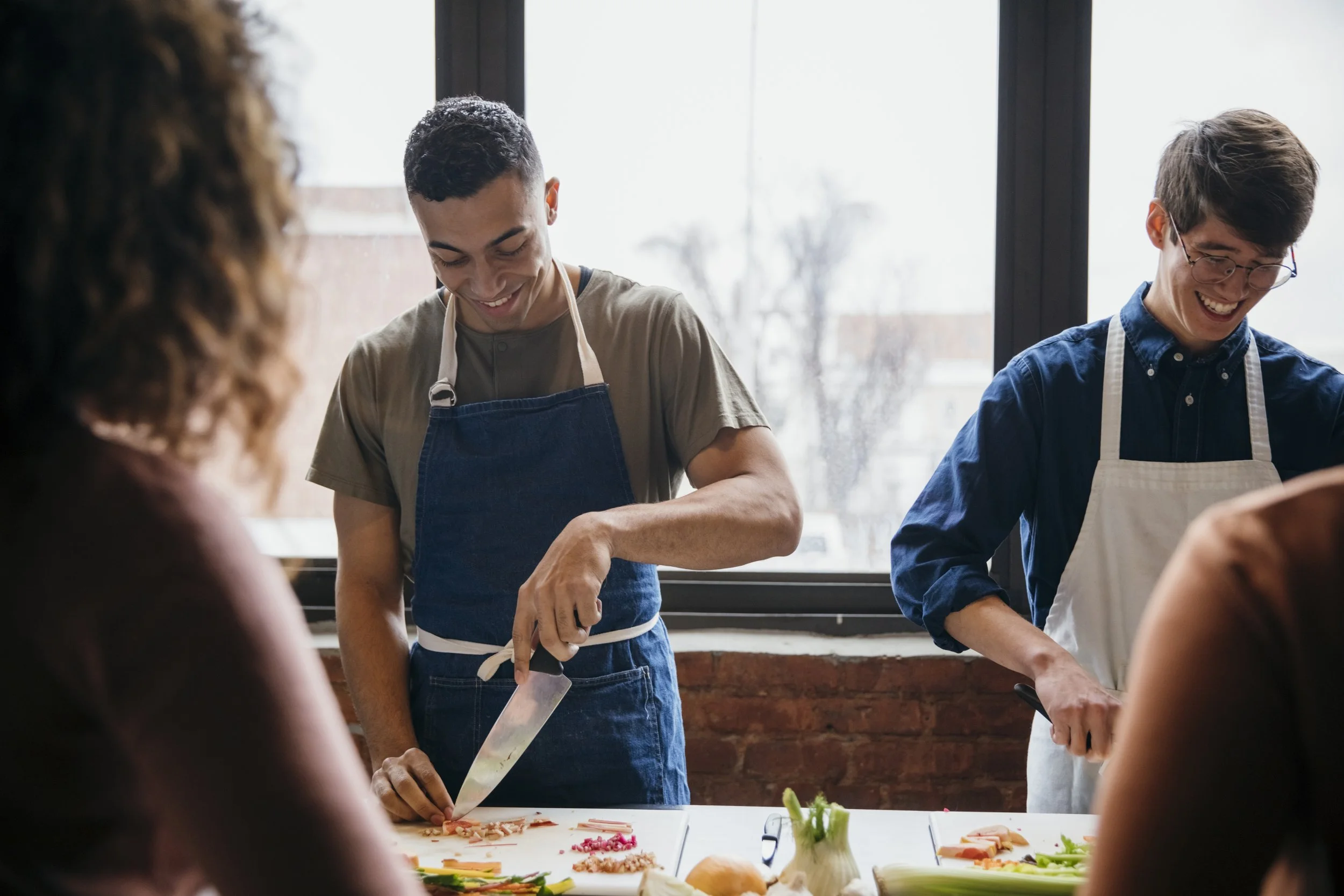 students using knives and cutting boards at a private cooking class at purple kale kitchenworks