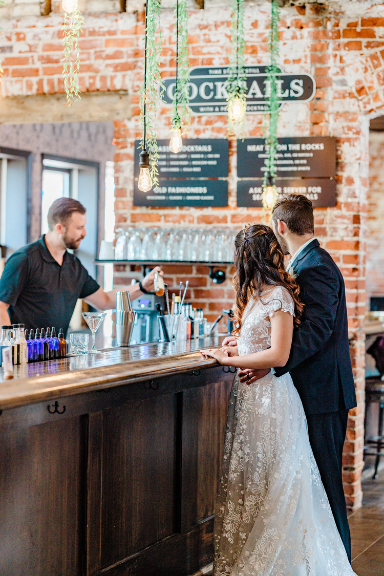 A bartender serves the bride and groom during their wedding at Timekeeper's Wausau Historic Depot.