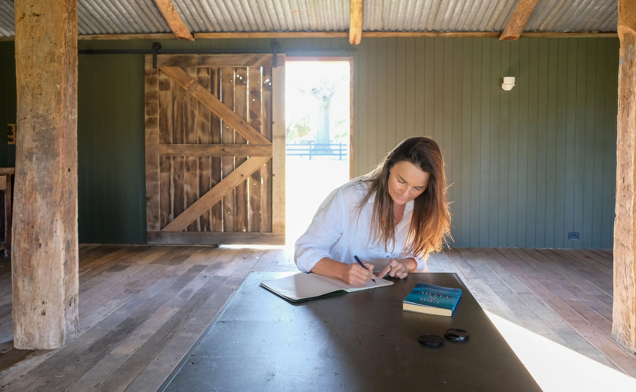 A peaceful writing nook and creative workspace by a window overlooking the farm gardens.