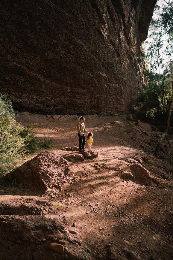 Family walking beneath sandstone cliffs at Paradise Falls in the High Country