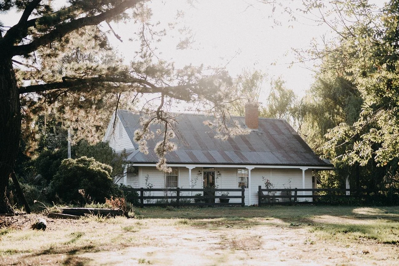 Restored 1860s weatherboard cottage at Dunmore Farm surrounded by established gardens and trees