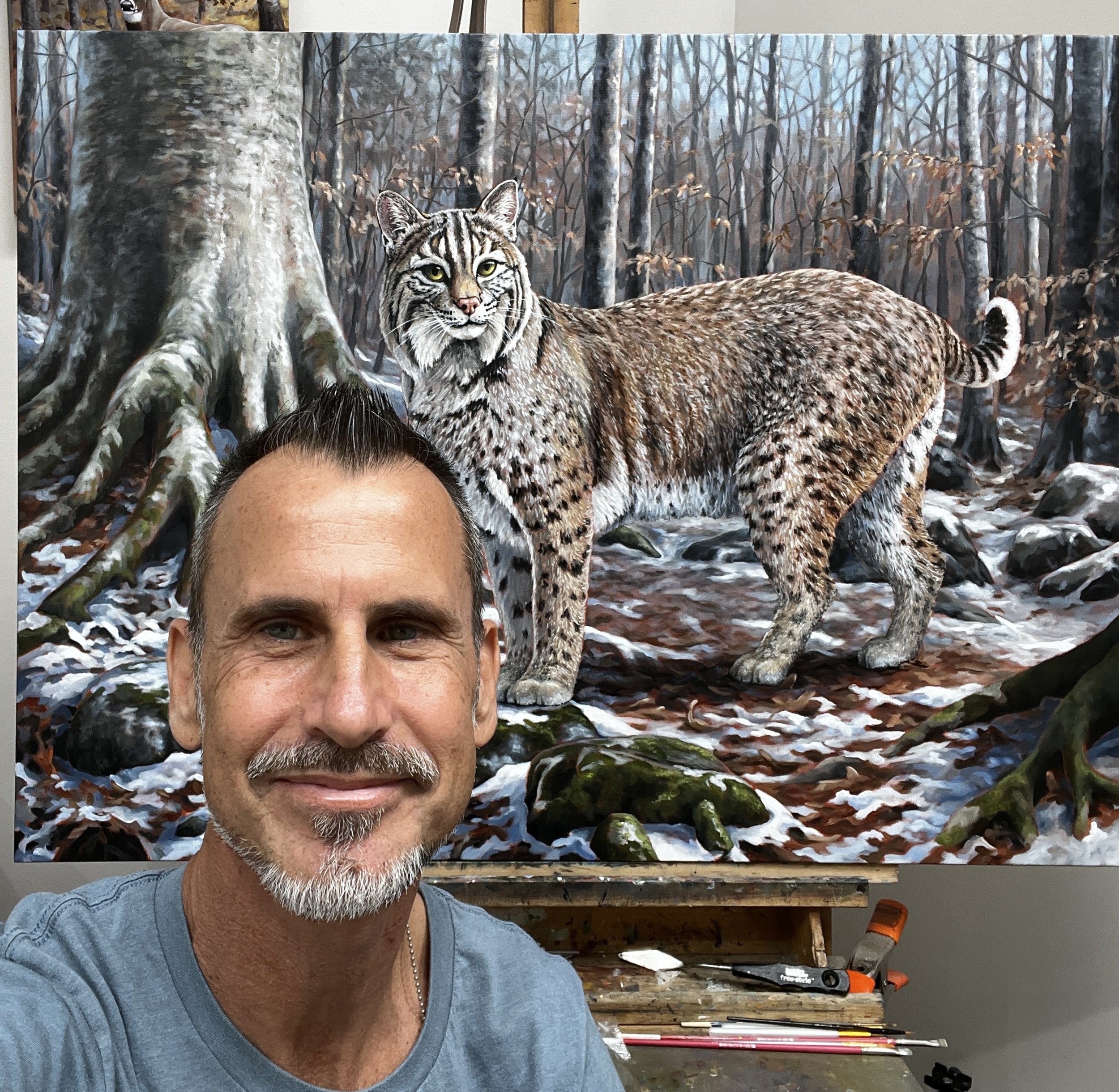Wildlife Artist Matt Tomko with his Bobcat painting at his Durham, North Carolina studio.