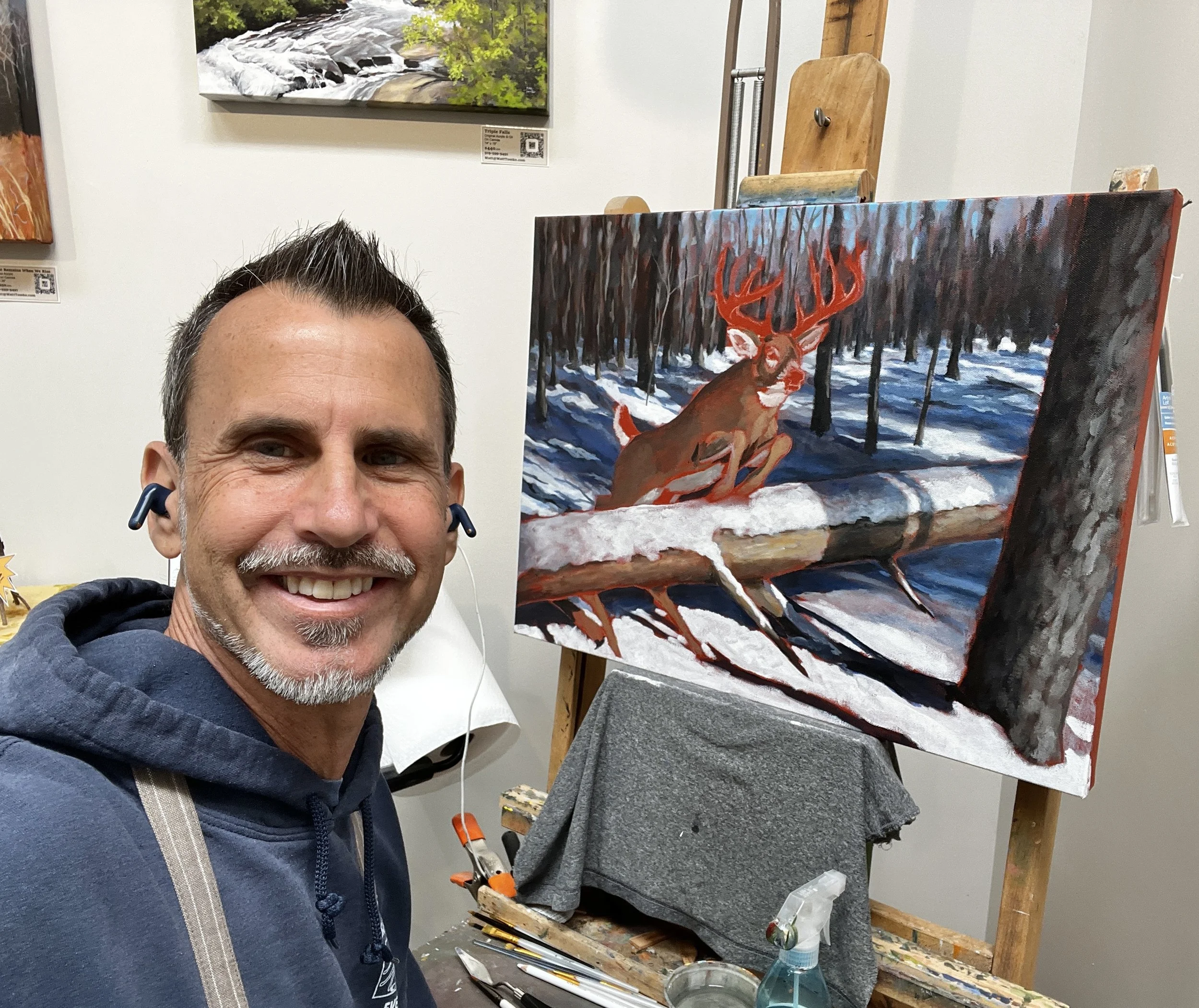 Wildlife Artist Matt Tomko in his studio beside a deer painting in progress.