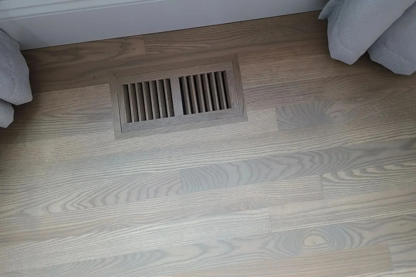 Installation of new red oak hardwood flooring with flush mount oak vents.