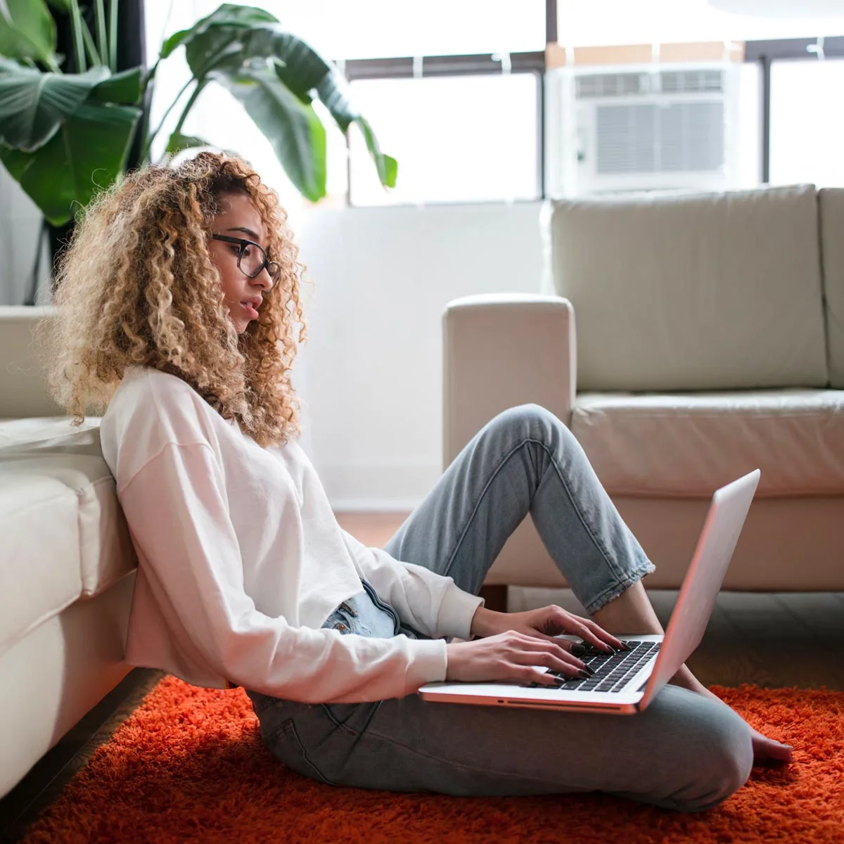 girl working on a laptop in her clean home