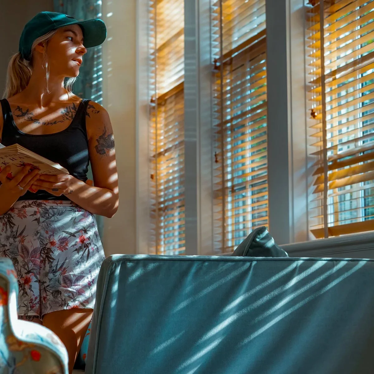girl looking through the window blinds