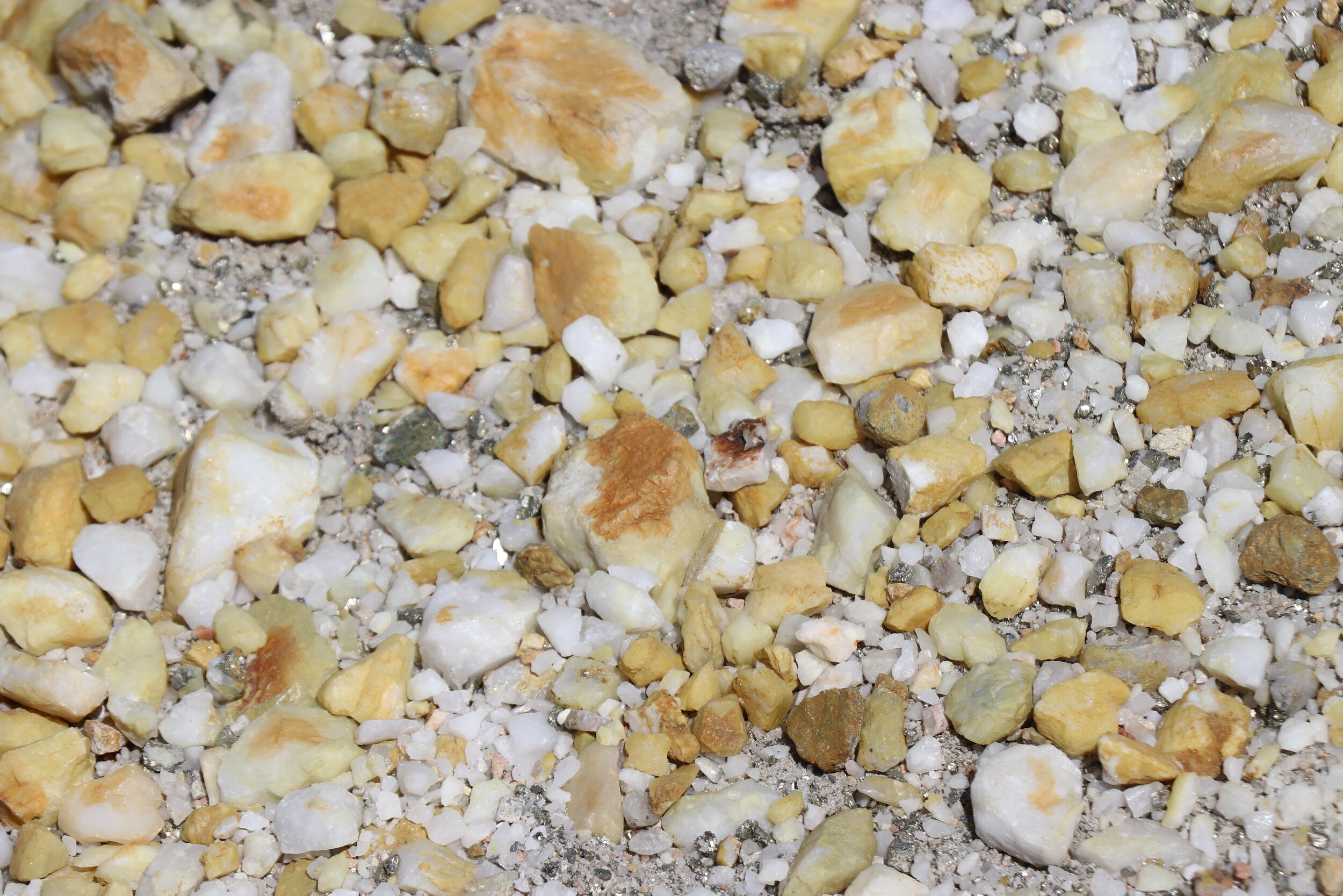 The ground remains covered in primarily yellow/red rocks with numerous pyrite chunks.