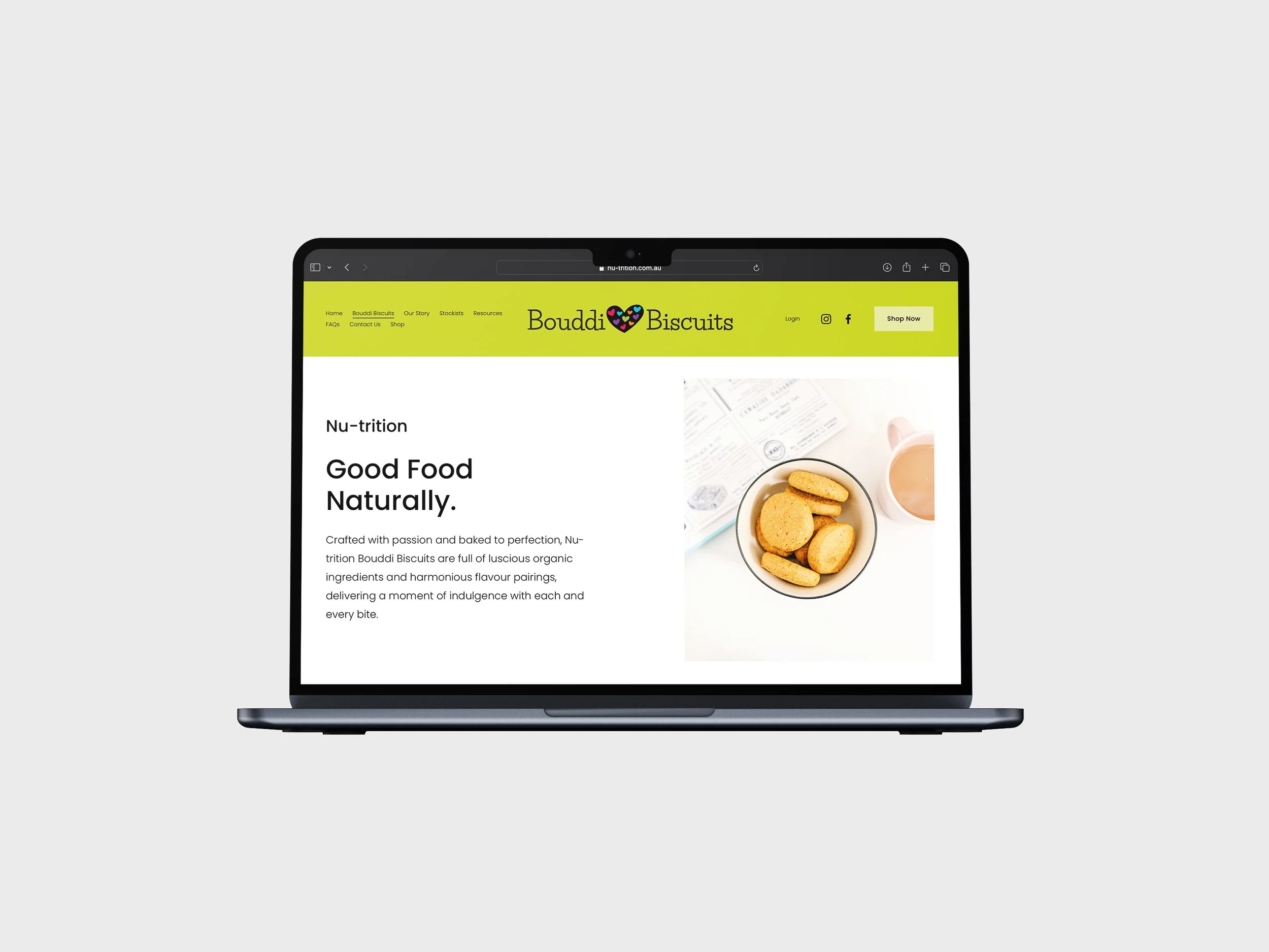A laptop displaying the homepage of Bouddi Biscuits website, featuring a green header with navigation links and a photo of biscuits in a bowl.