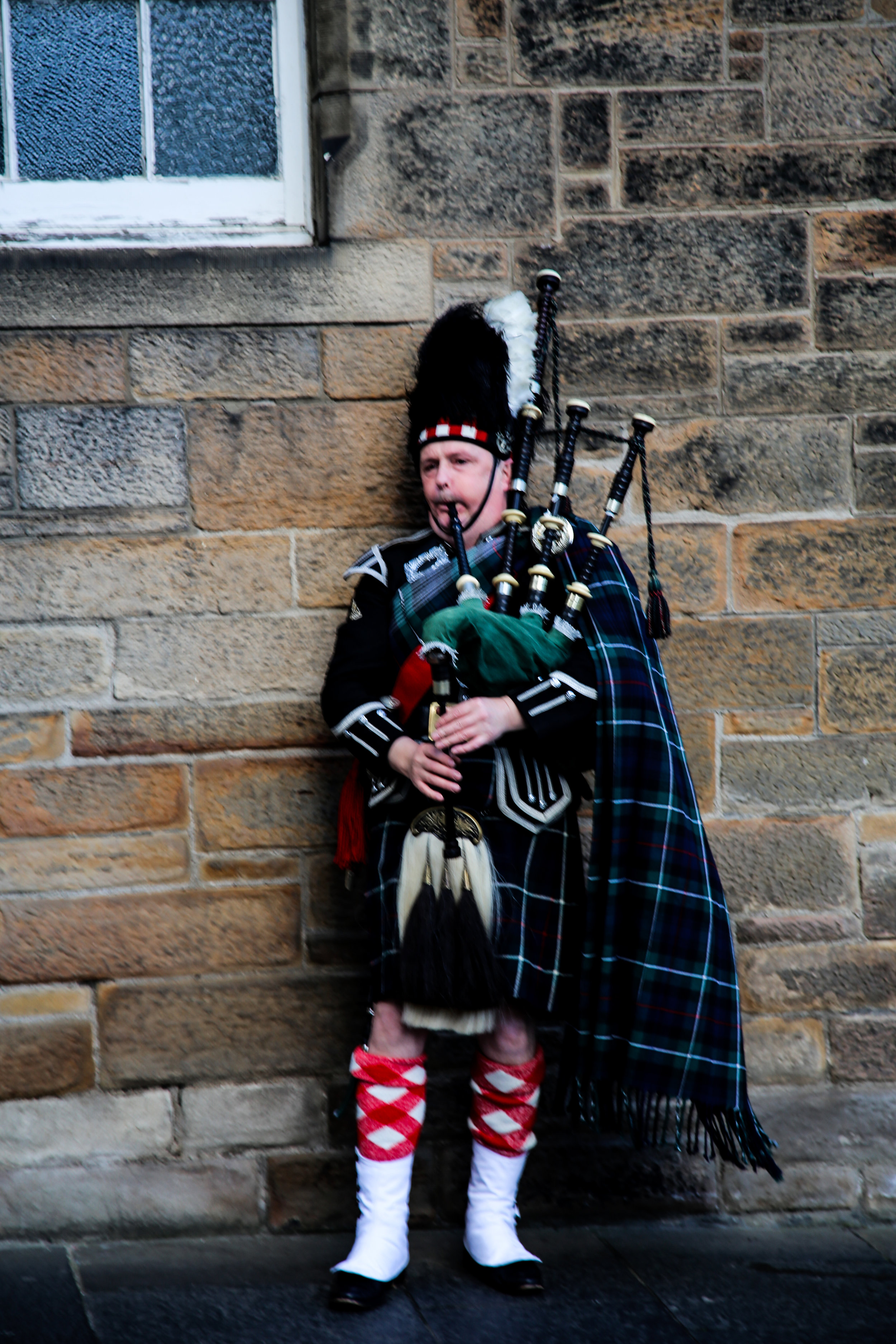 Scottish highlander playing bagpipes Edinburgh