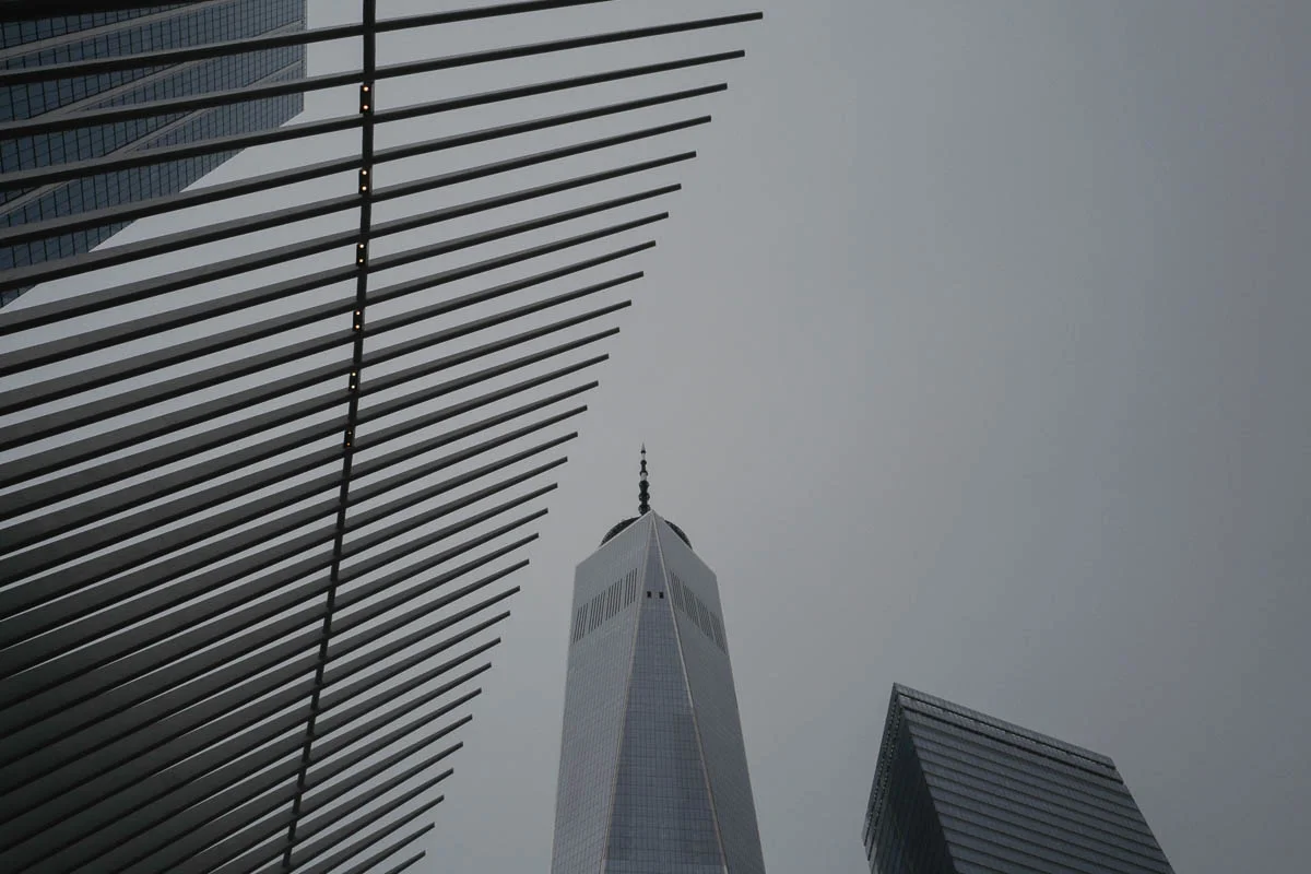 The spiny edges of the Oculus frame One World Trade Center at center.