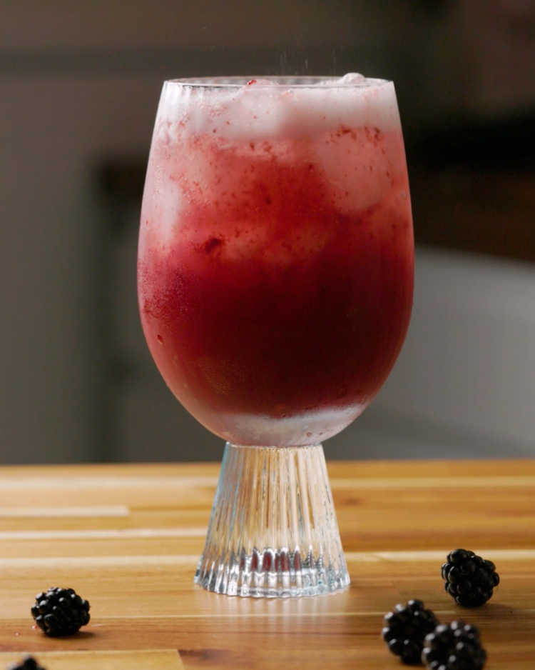 blackberry hugo spritz on counter surrounded by blackberries