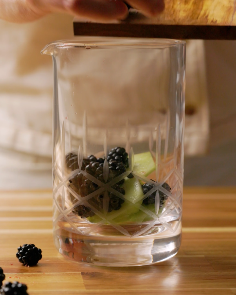 fresh blackberries and sliced cucumbers in a glass