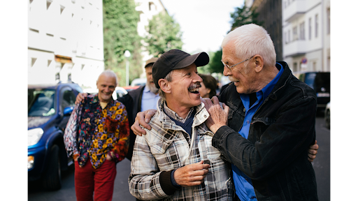 Older adults warmly greeting each other with arms around shoulders