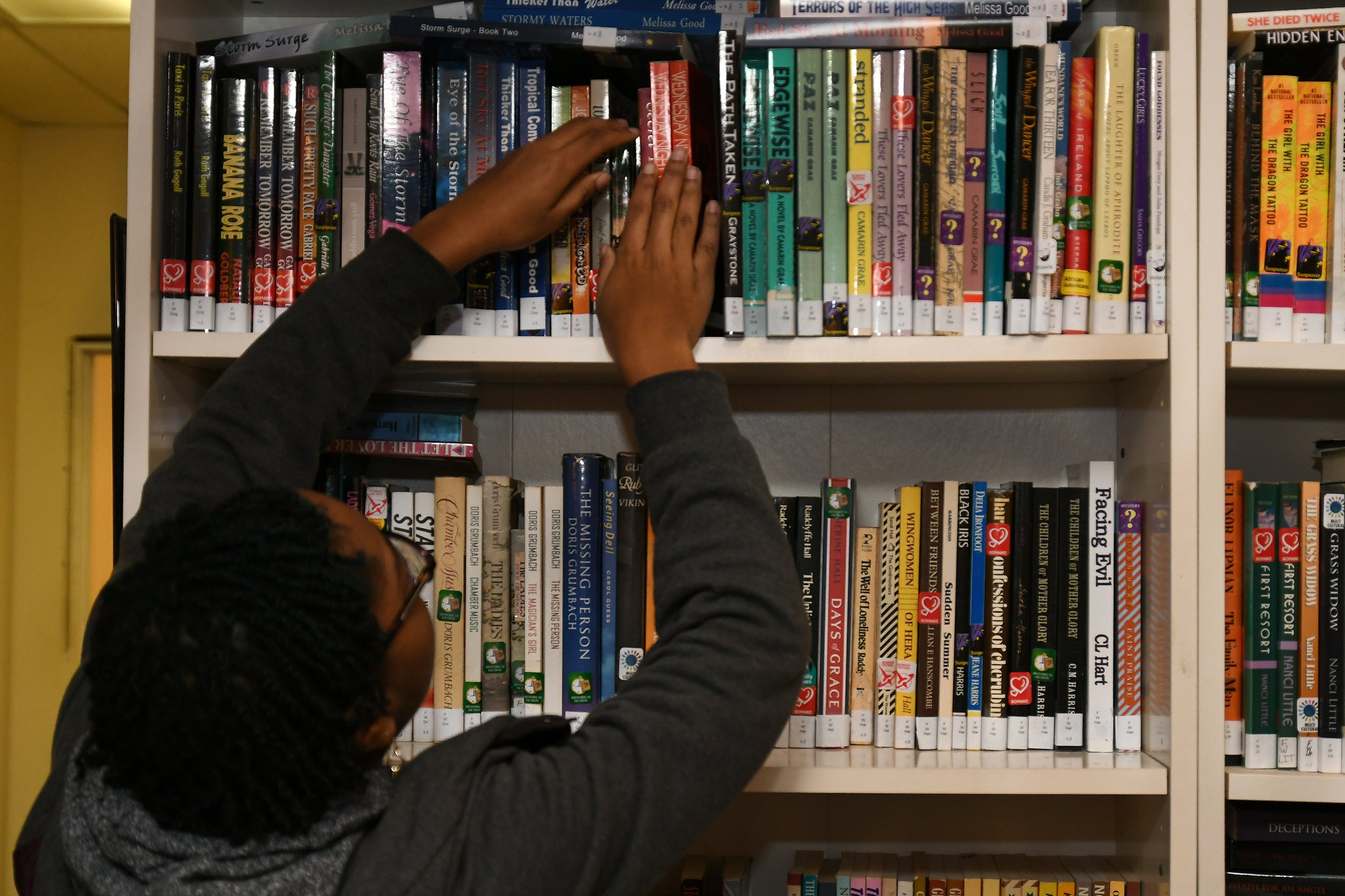 Person in front of library bookshelf.