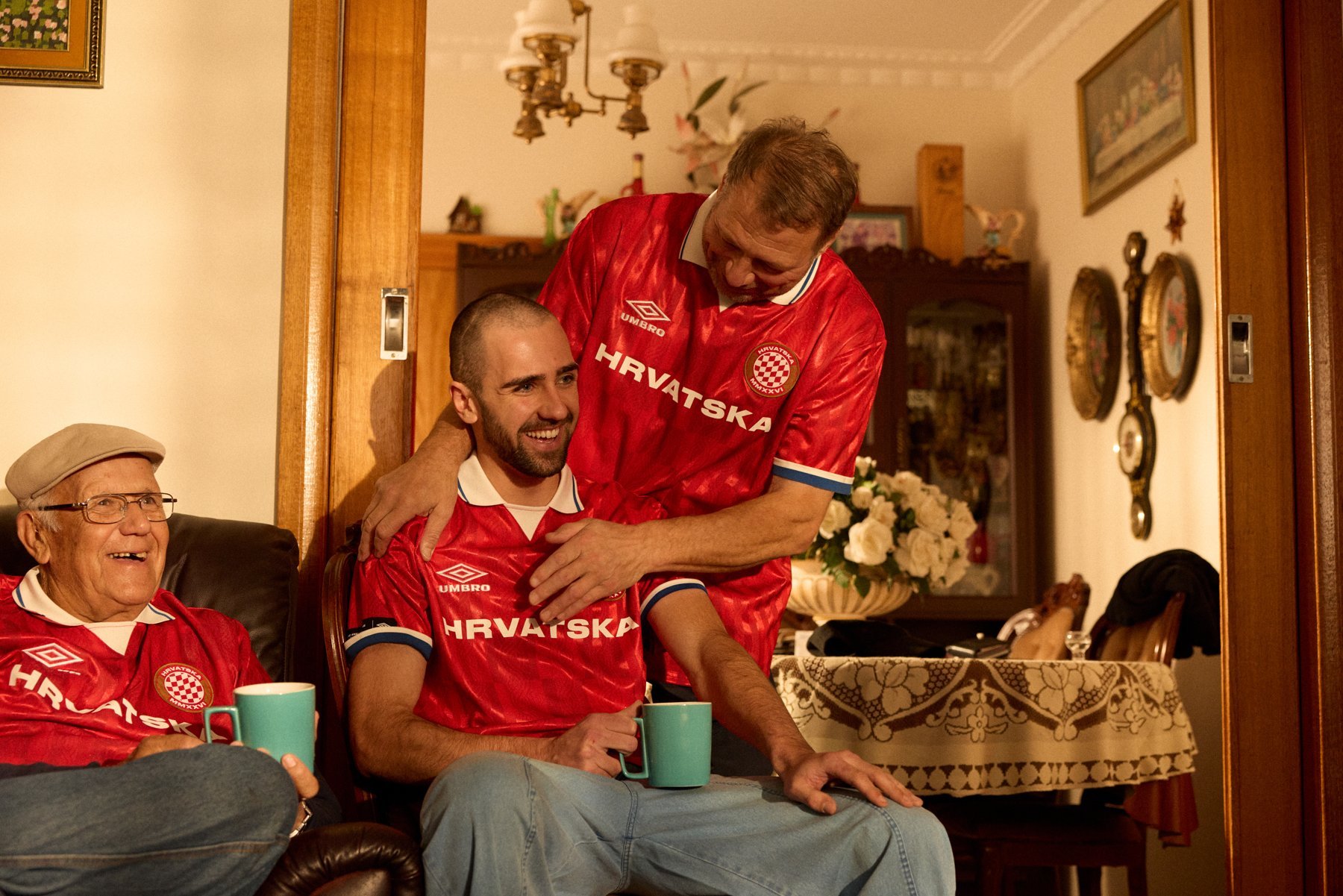 People gathered at home wearing red Umbro Hrvatska football shirts