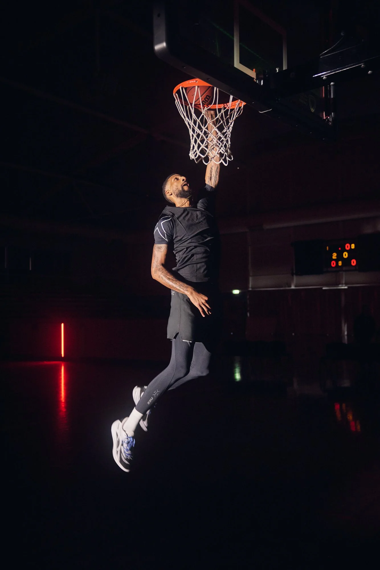 Basketball player jumping towards the hoop in 2XU sportswear