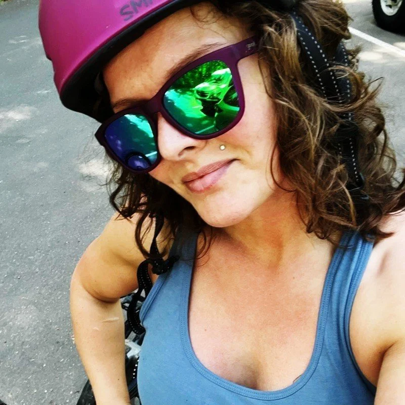Picture of Hannah wearing a helmet and sunglasses after mountain biking