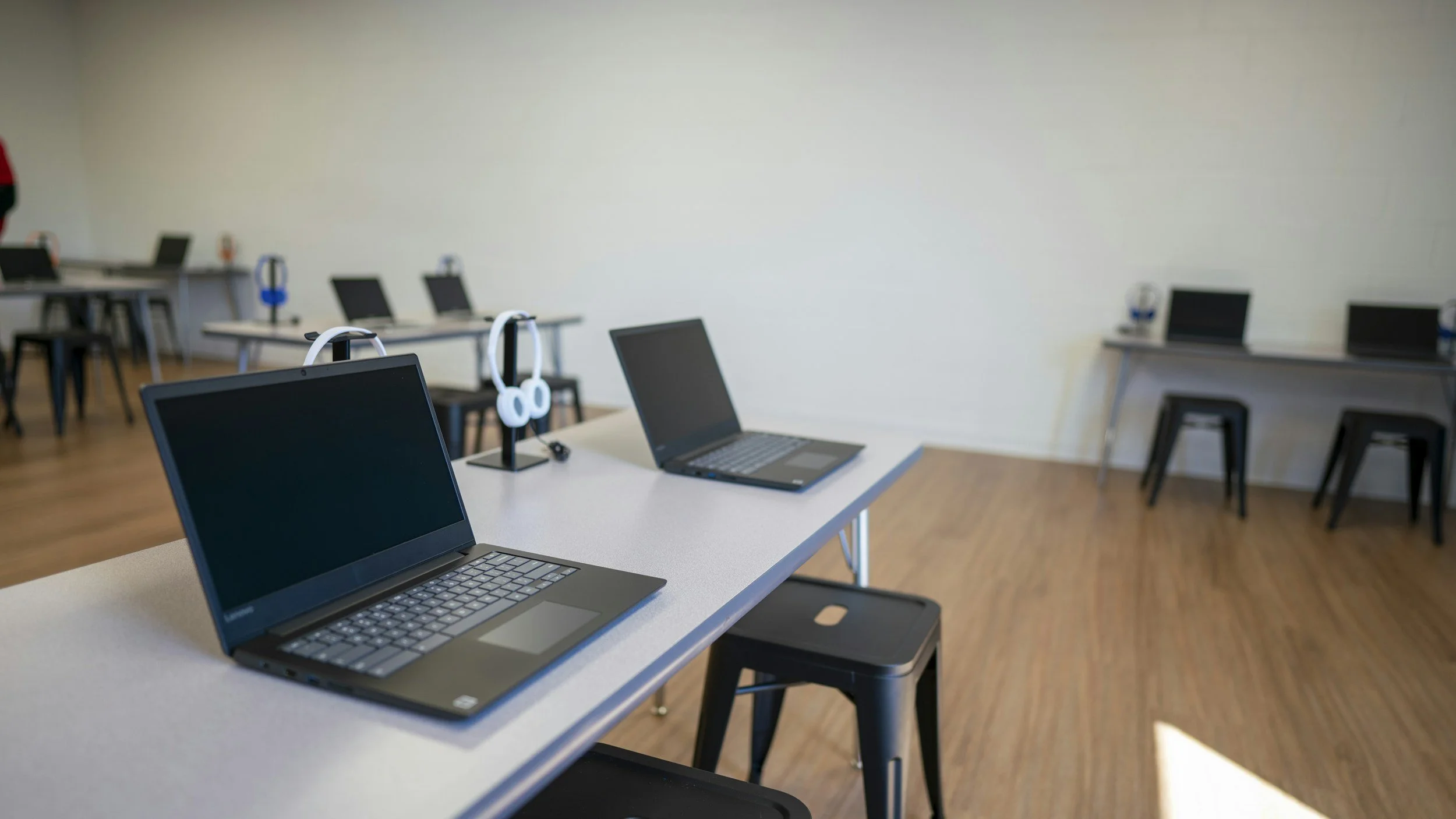 classroom with tall desks and laptops on the desk