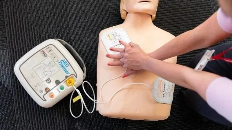 Photo of defibrillator and training manikin.