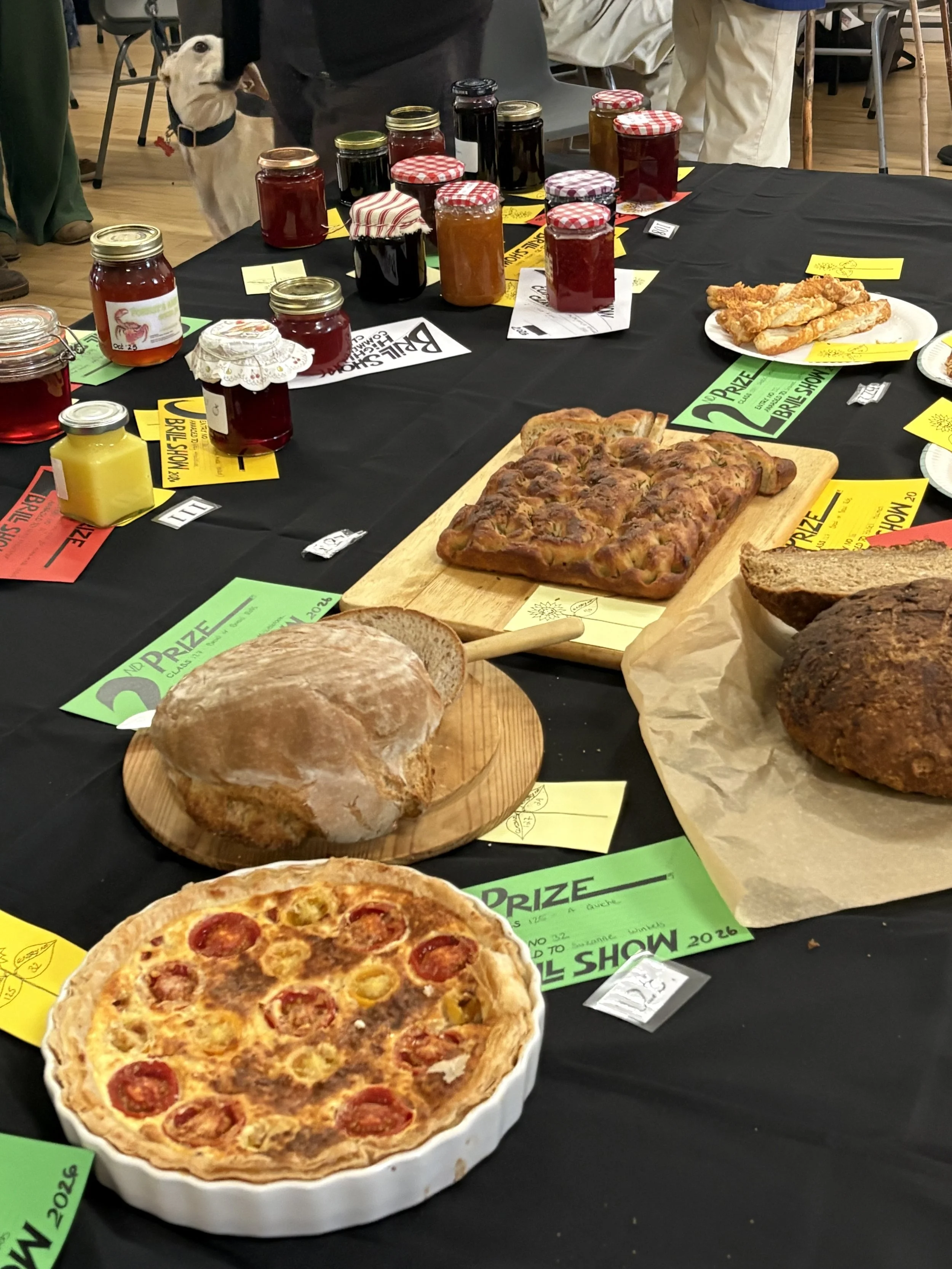 Photo of quich, loaves of bread and jars of jam arranged on a table