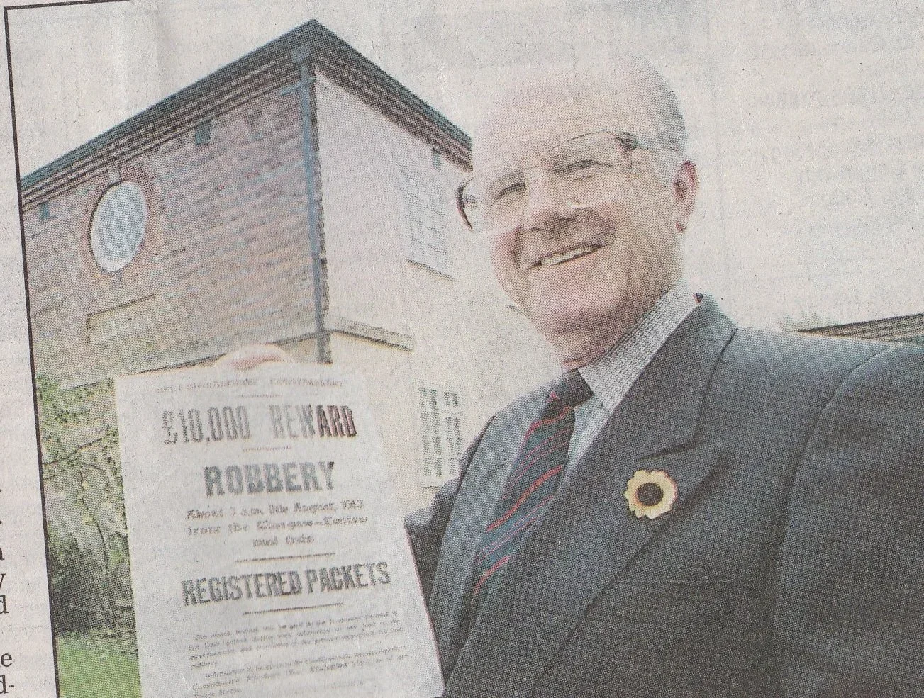 Old newspaper image of man holding £10,000 Reward poster for the robbers.