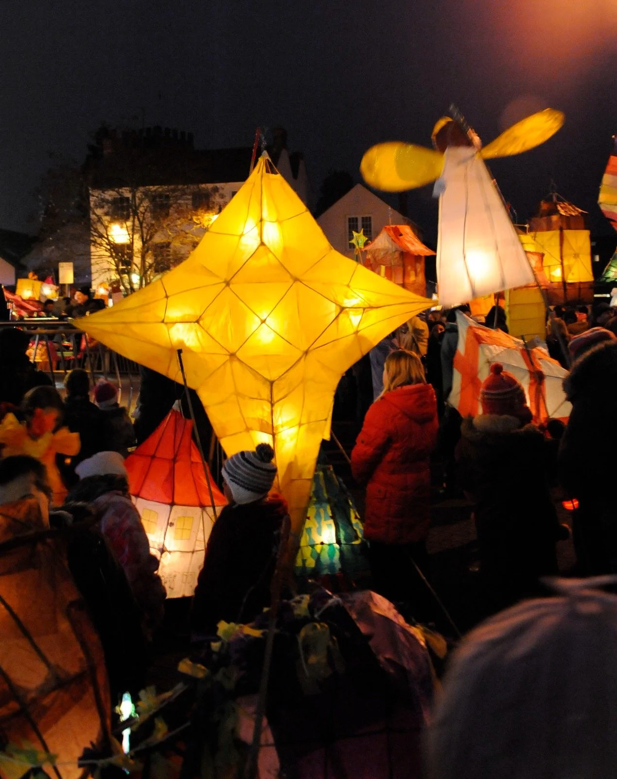 Photo of large colourful paper lanterns carried by children