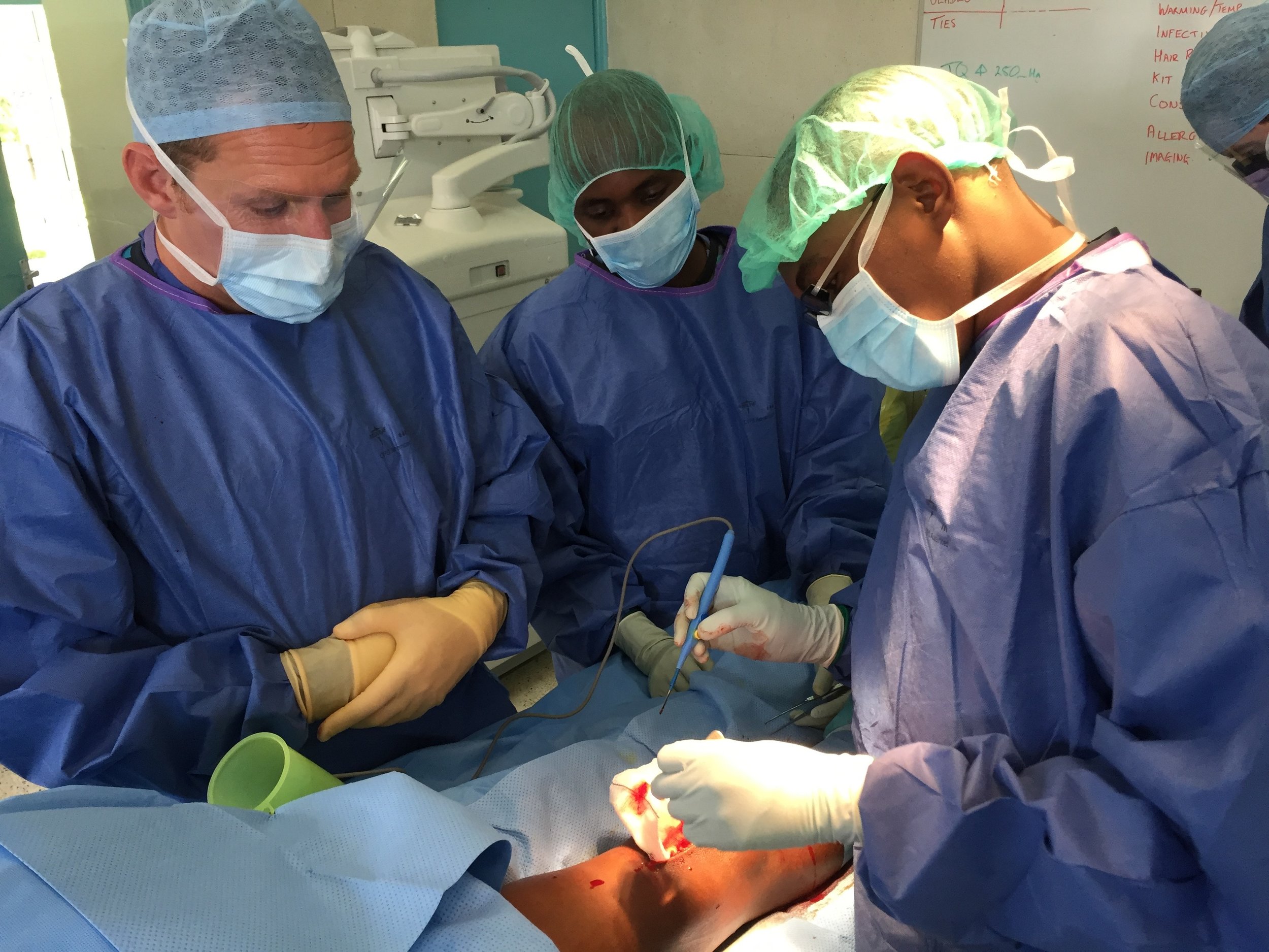  Njeri performing a surgical procedure, Rob overseeing &amp; Kenyan Scrub nurse 