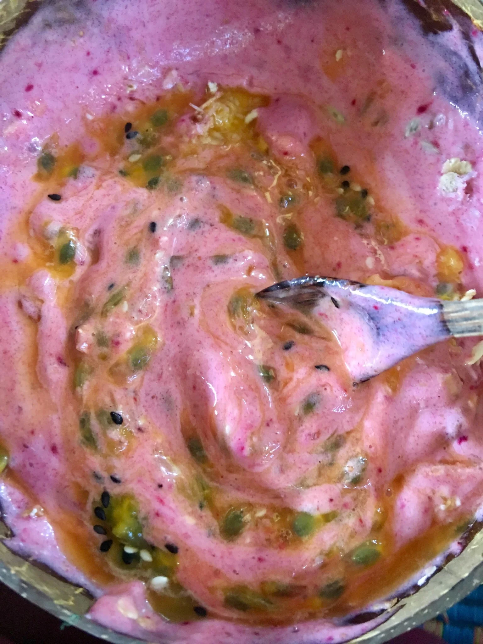 A half-eaten strawberry, passion fruit smoothie bowl. Blossoms Cafe, Pai, Thailand.