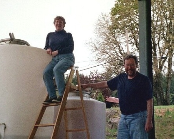 Mike and Vonnie Landt, posing in front of tanks used for winemaking.