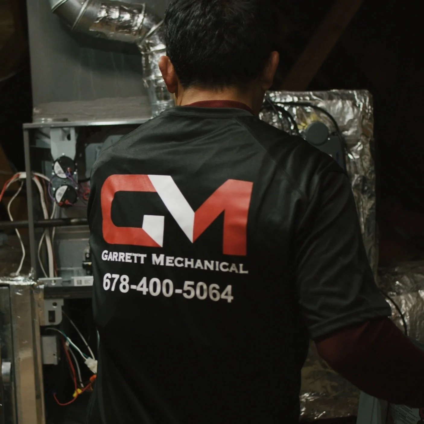 HVAC technician working inside a mechanical unit during a service call.