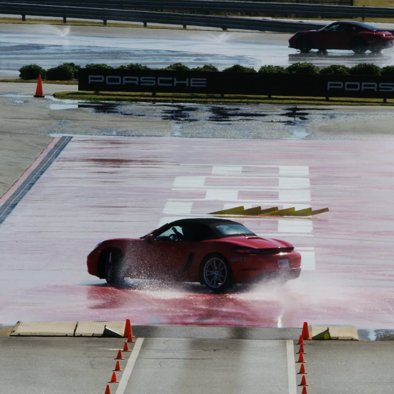 Sports car driving on a wet track during a Tilke automotive production shoot.