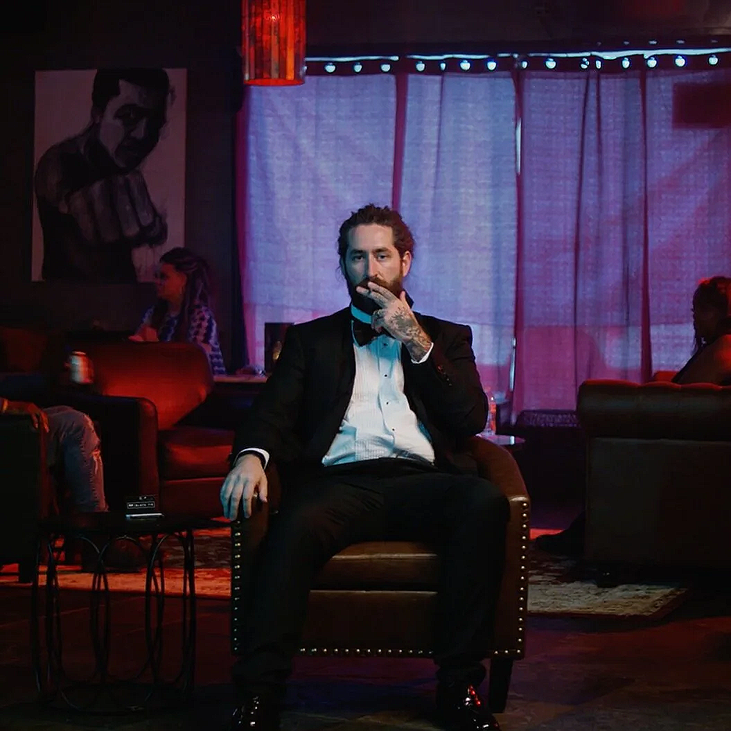 Man in a tuxedo sitting in a lounge setting from the “Black Tie” CBD commercial.