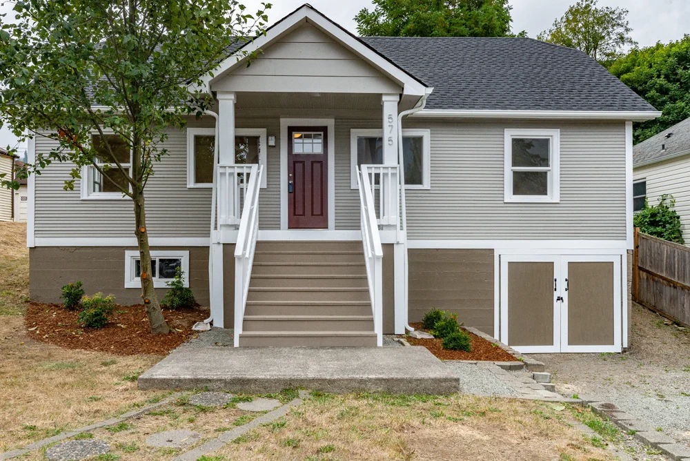 Final view of home with repaired cedar siding, rebuilt porch / stairs and new roof.