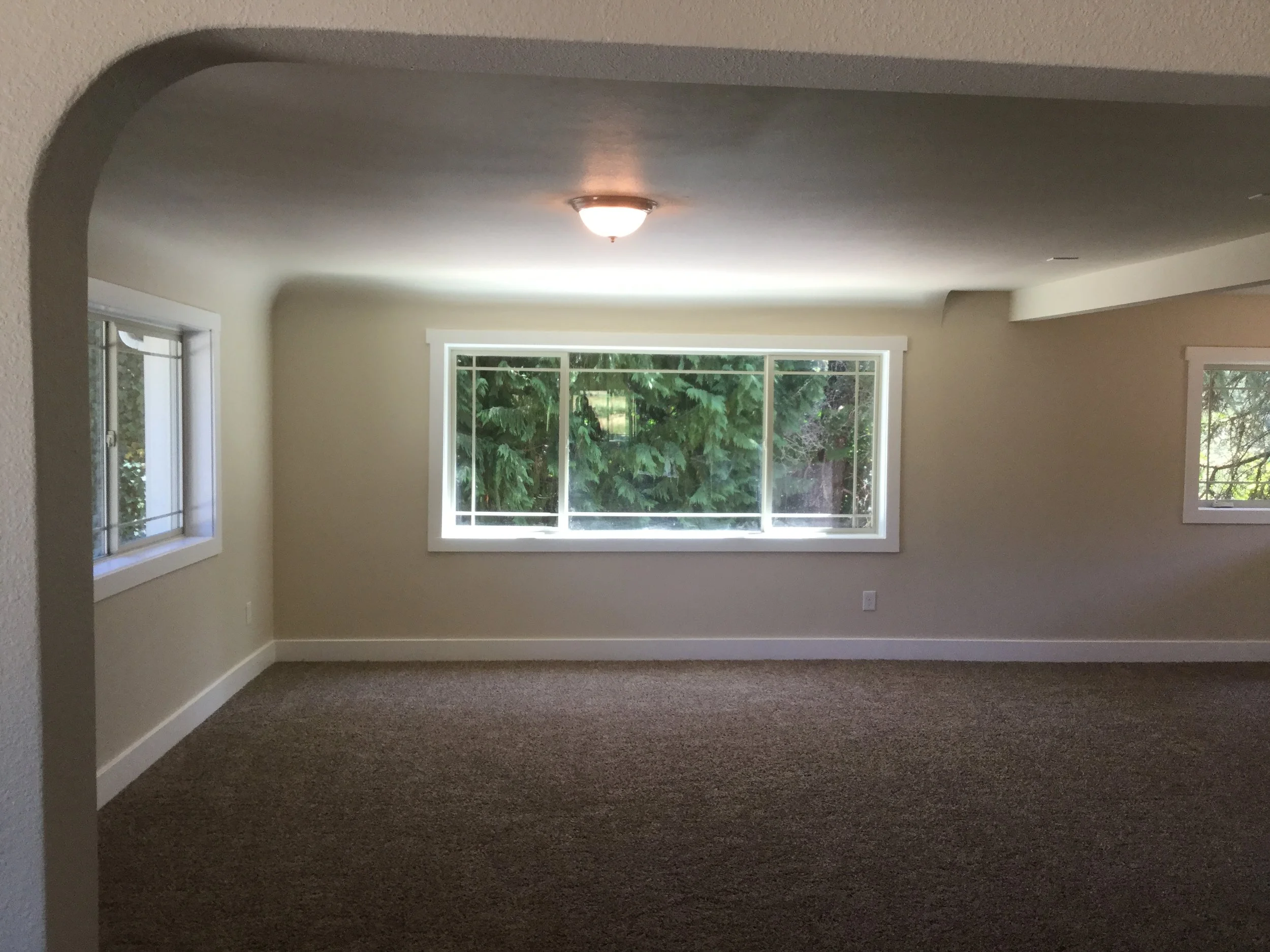 Living room - new interior finishes, new almond color thermal vinyl windows with white board trim.