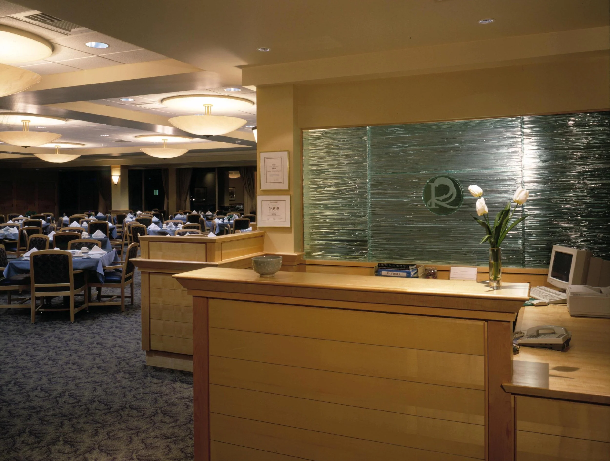 Reception desk with decorative glass wall beyond.