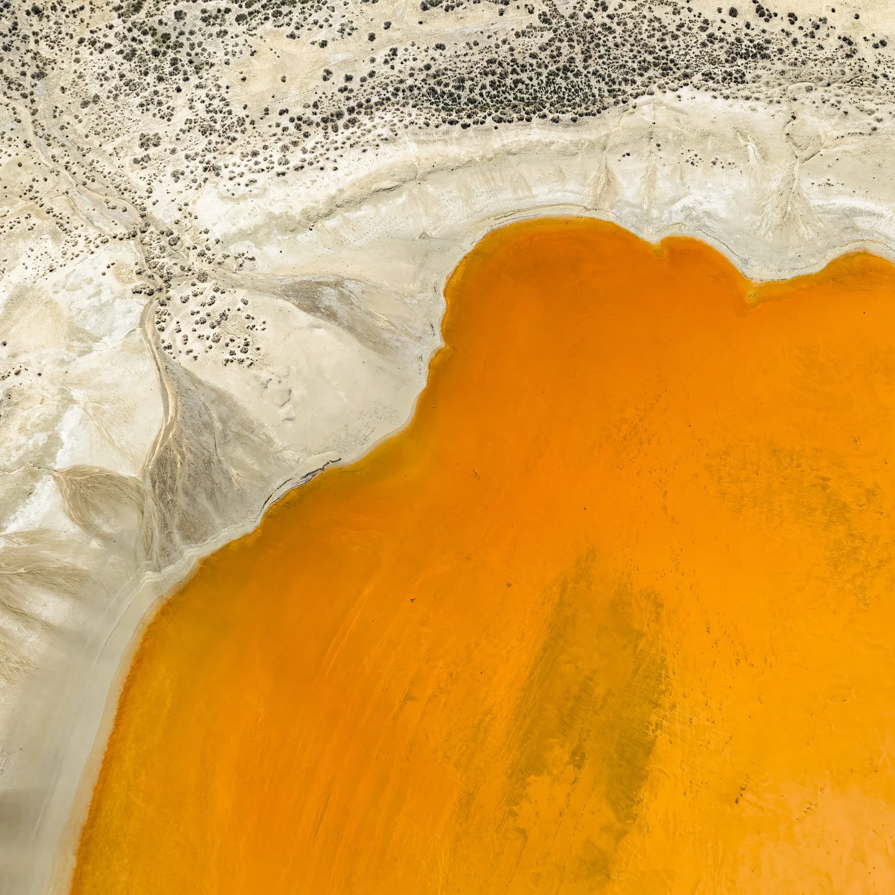 Burn. Abstract landscape photograph exploring intense earth tones, irregular patterns and geological forms transformed by an elevated perspective.