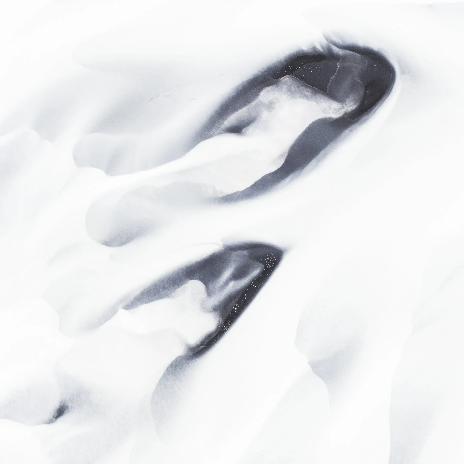 Flow. Landscape of a glacial river viewed from above and transformed into an abstract composition of flowing forms, muted colour and intricate natural patterns.