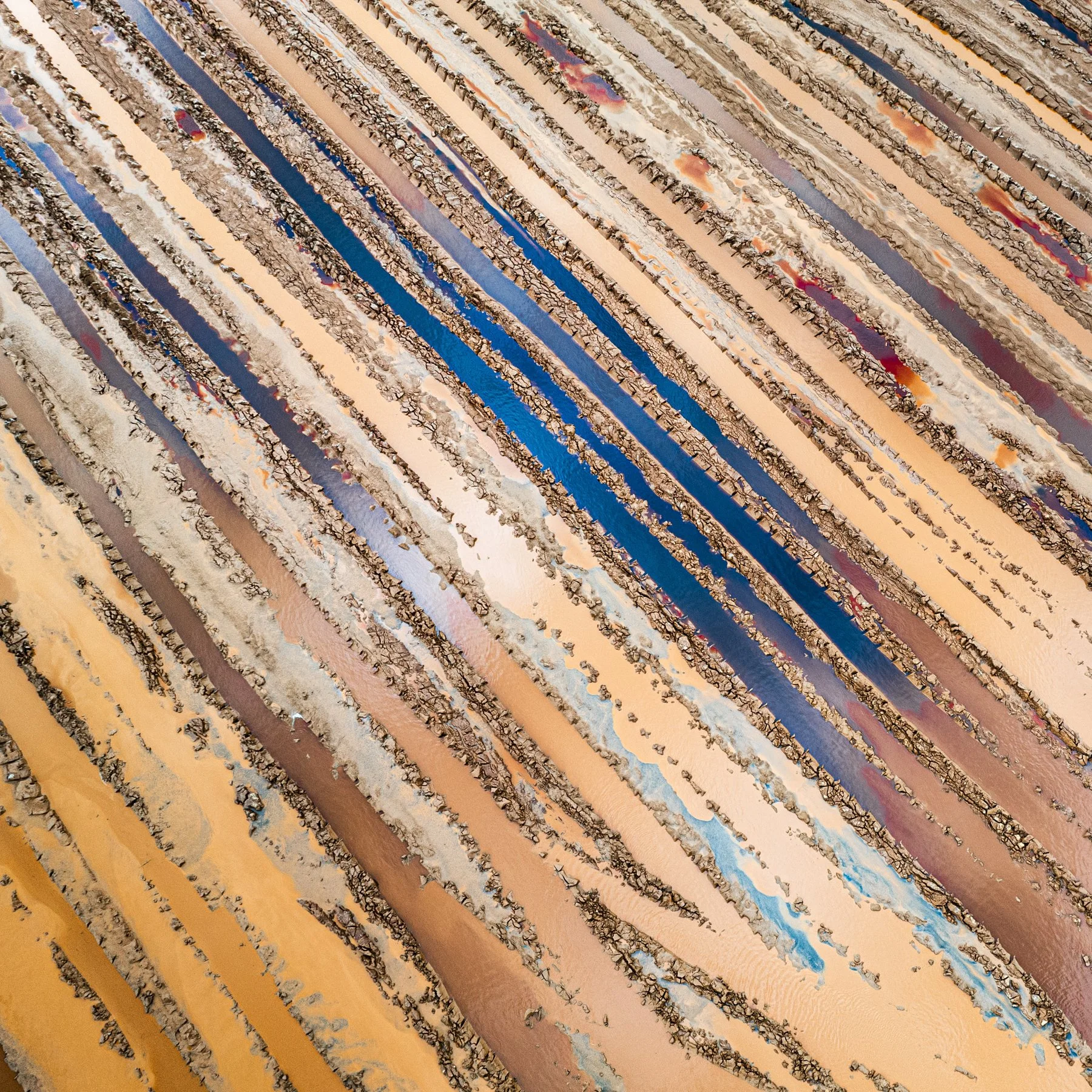 Strata. Photograph of a landscape reduced to sweeping lines, contrasting colours and geometric patterns, blurring the boundary between landscape and abstraction.
