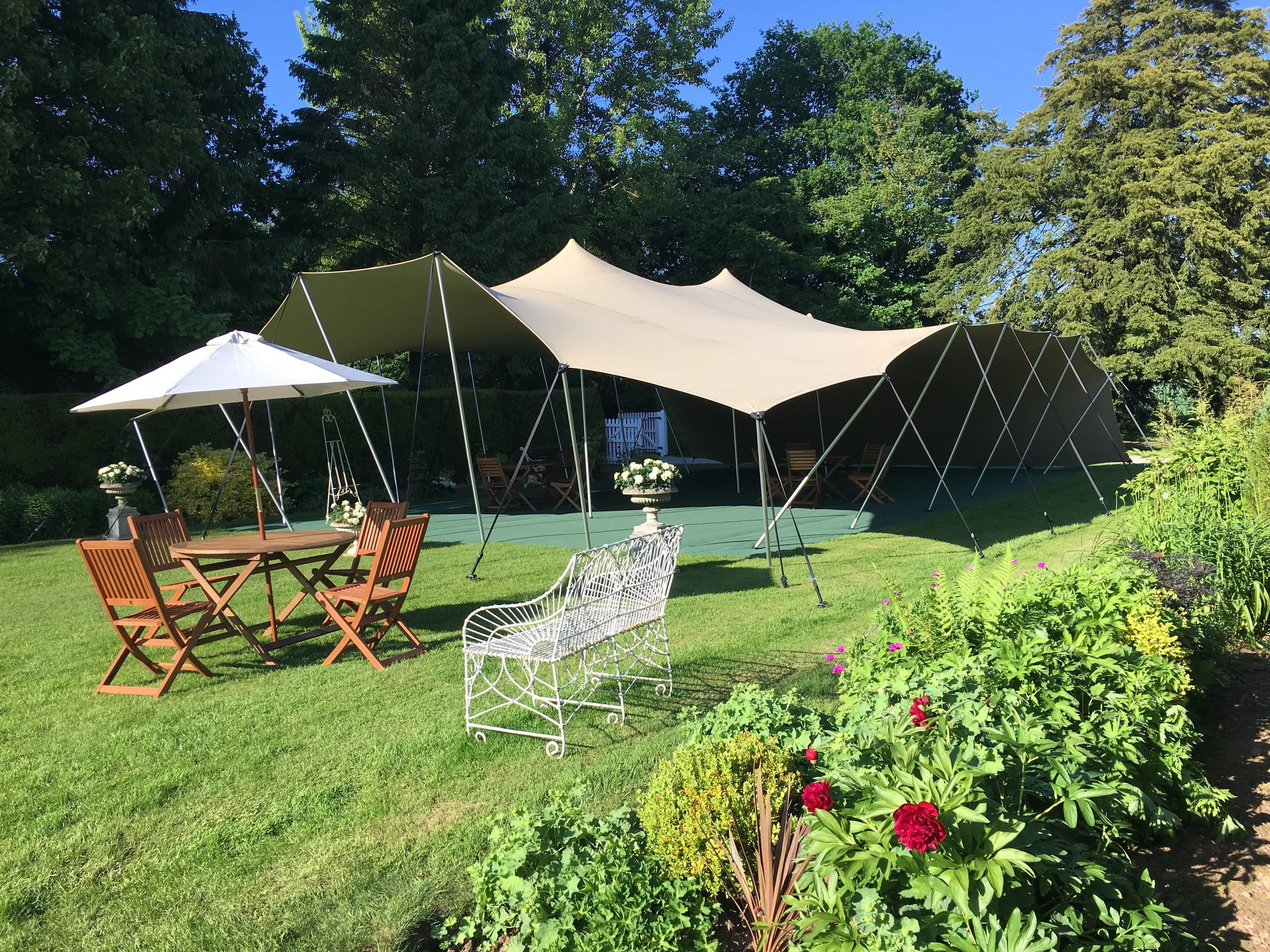 10m x 15m Garden Party Stretch with green carpet under foot and garden furniture.