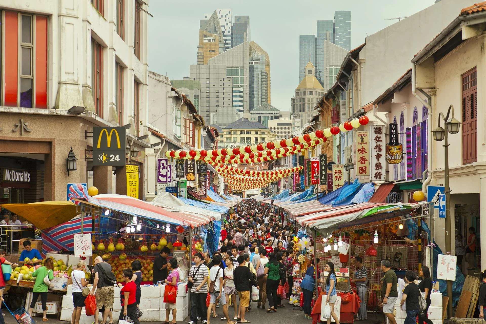 a busy street market in chinatown with lanturns and macdonalds sign