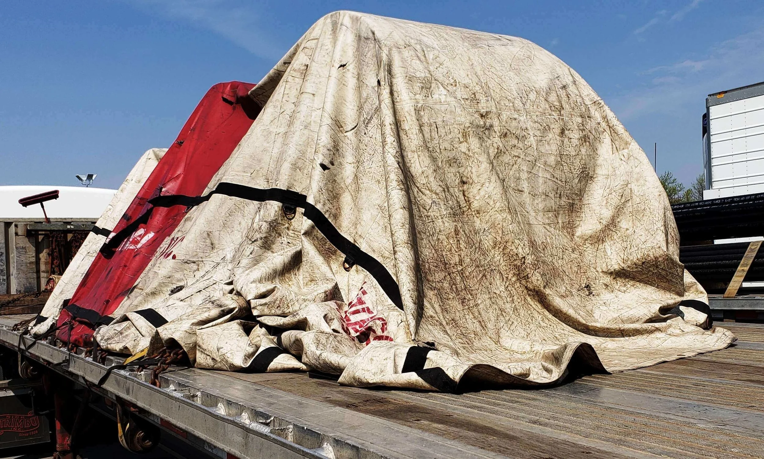 I-15: Rear of tarp not secured. This tarp will flap in the wind, ultimately destroying itself.