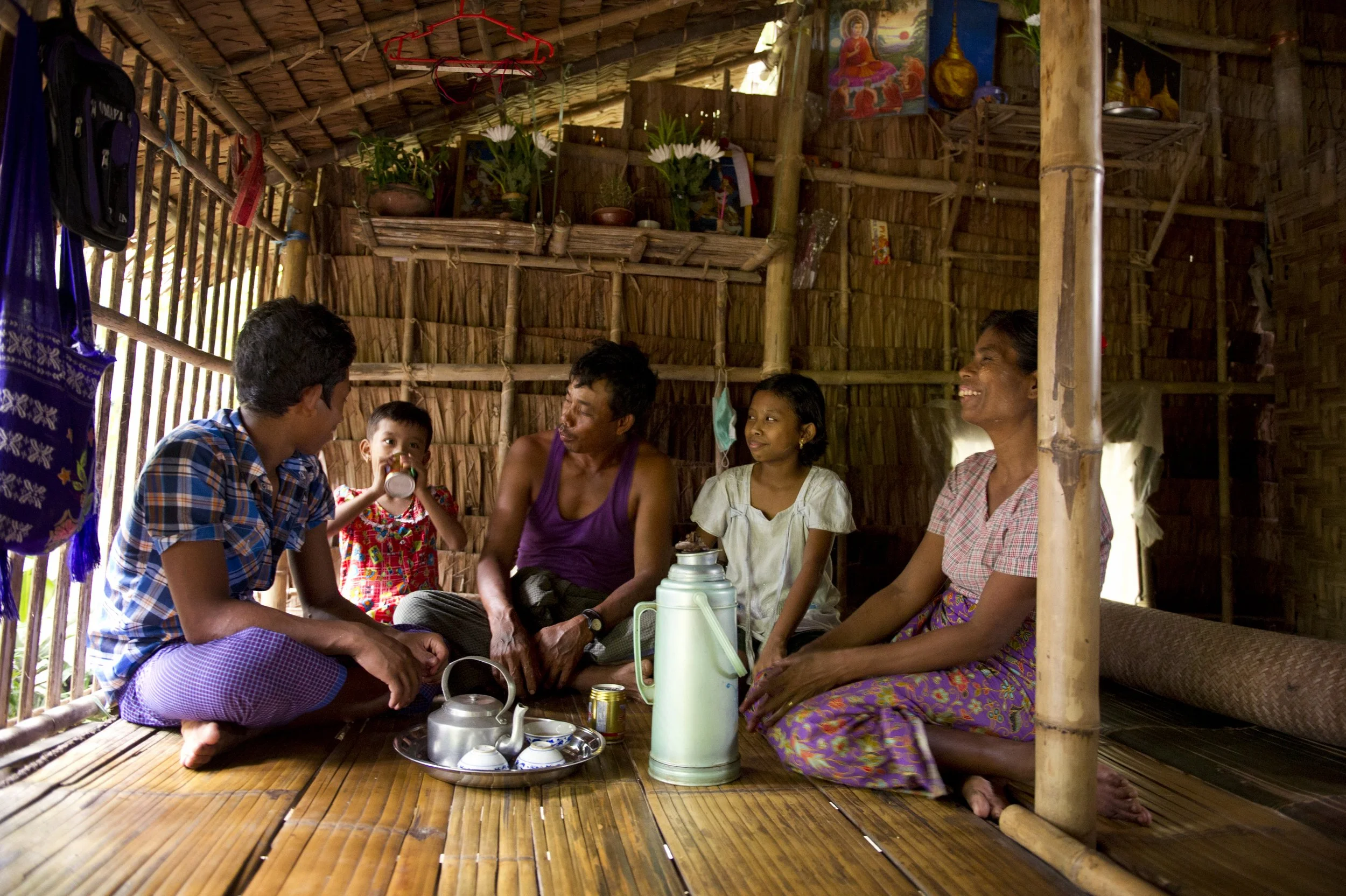 A family sitting together, located in Myanmar (Burma) in 2016.
