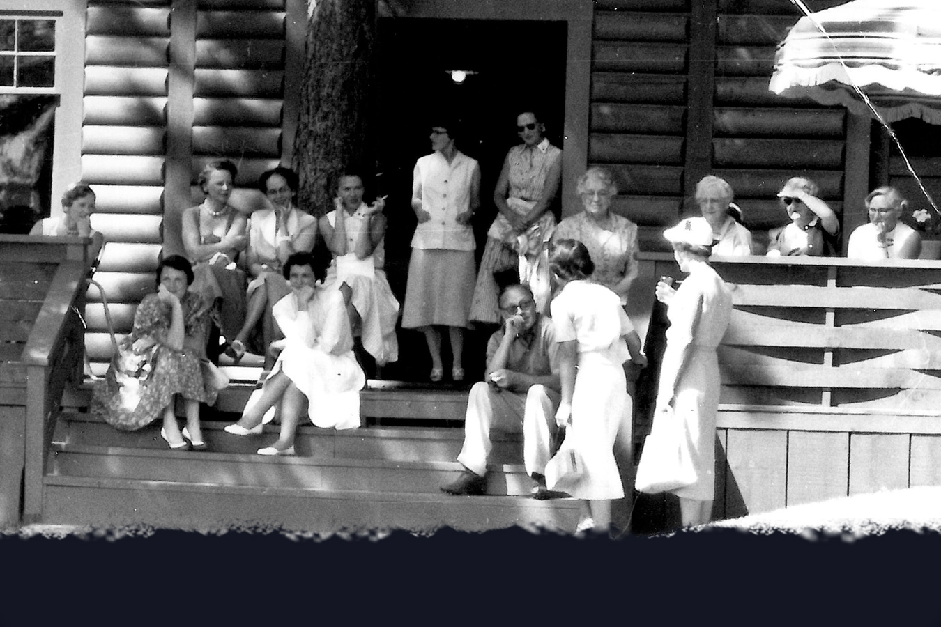  Comedian Jack Benny (seated in center) keeps an audience of female members entertained on his visit in 1956. 