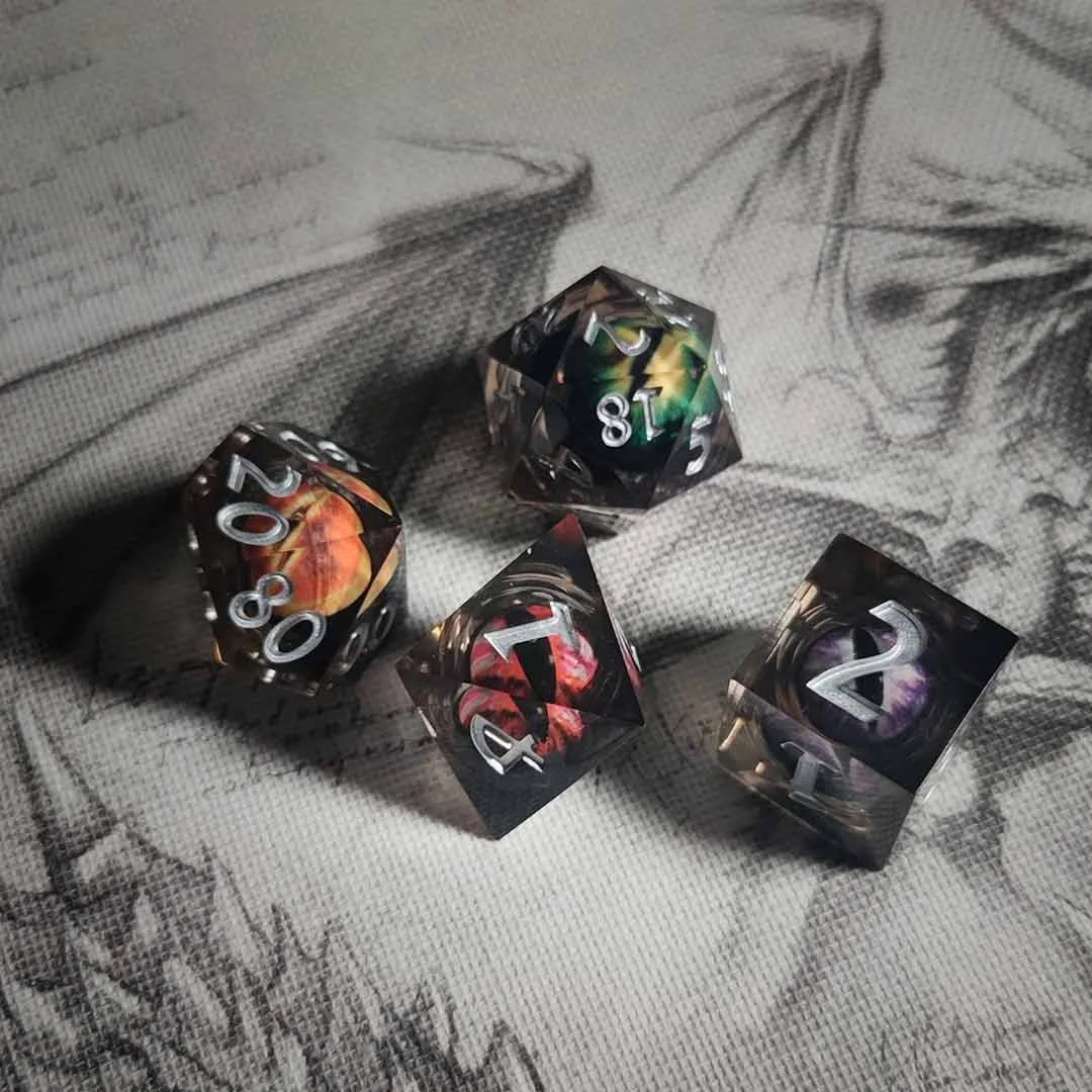 Cuatro dados de rol con diseños coloridos en un tapiz de tela con dibujos en gris