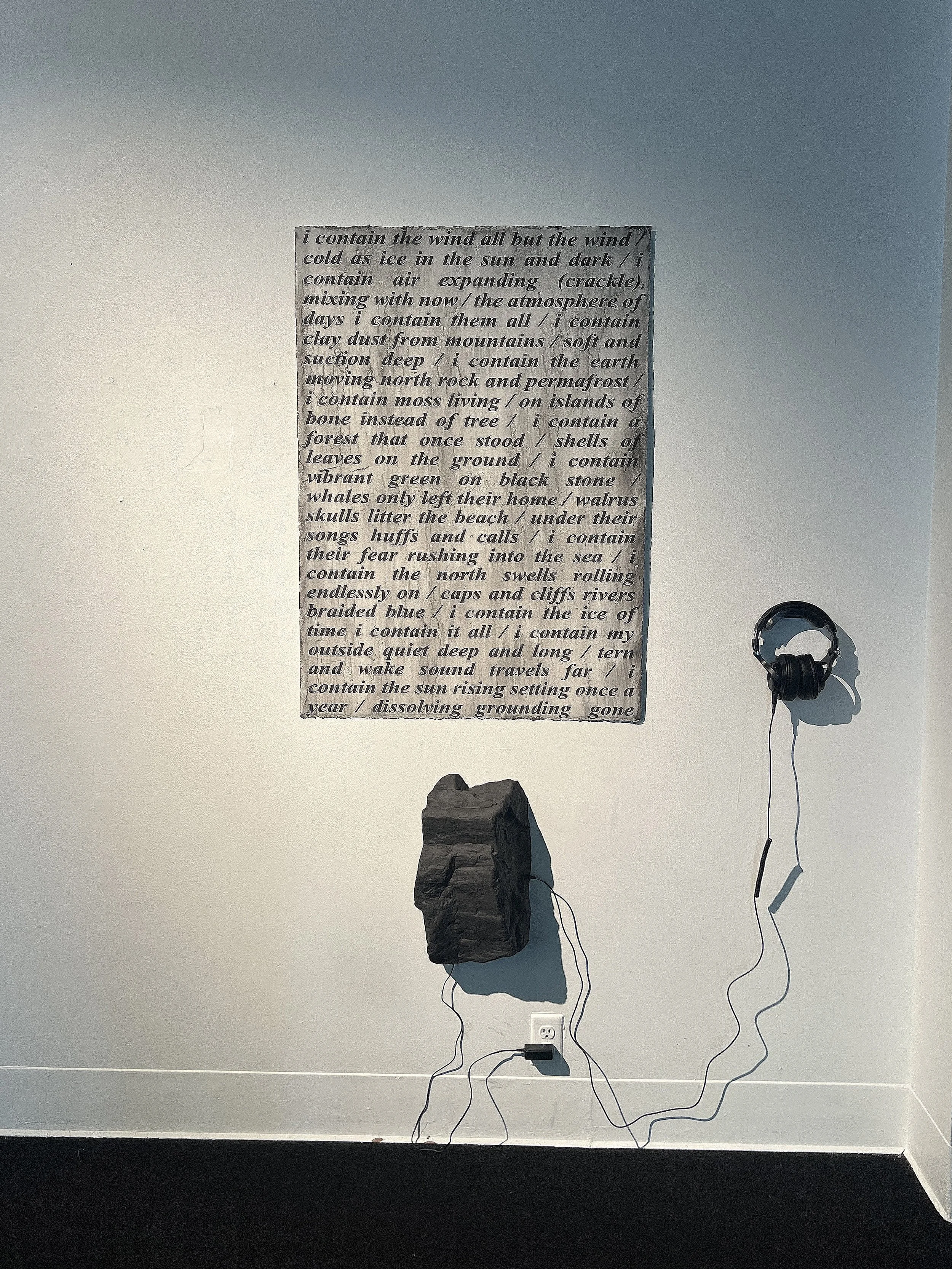  I Contain   Paper, clay collected from glacial moraine, carbon black, 3D-scanned rock from Svalbard cast in clay, headphones, Sound: glacial calving, voice 