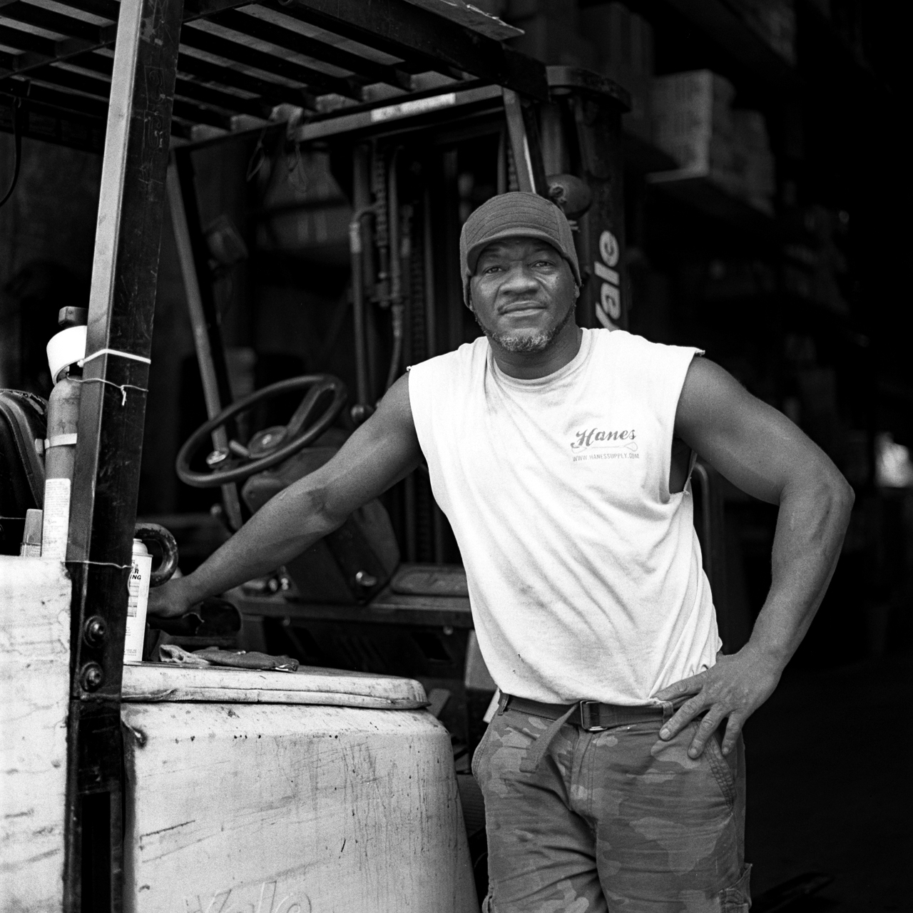  Robert, warehouse manager for Reinforcing Supply, beside his forklift. Previous to his position at Reinforcing Supply, Robert was a photographer for Russell Simmons' Def Jam and a printer at a photo lab in Manhattan.  Williamsburg, Brooklyn, N.Y. (S