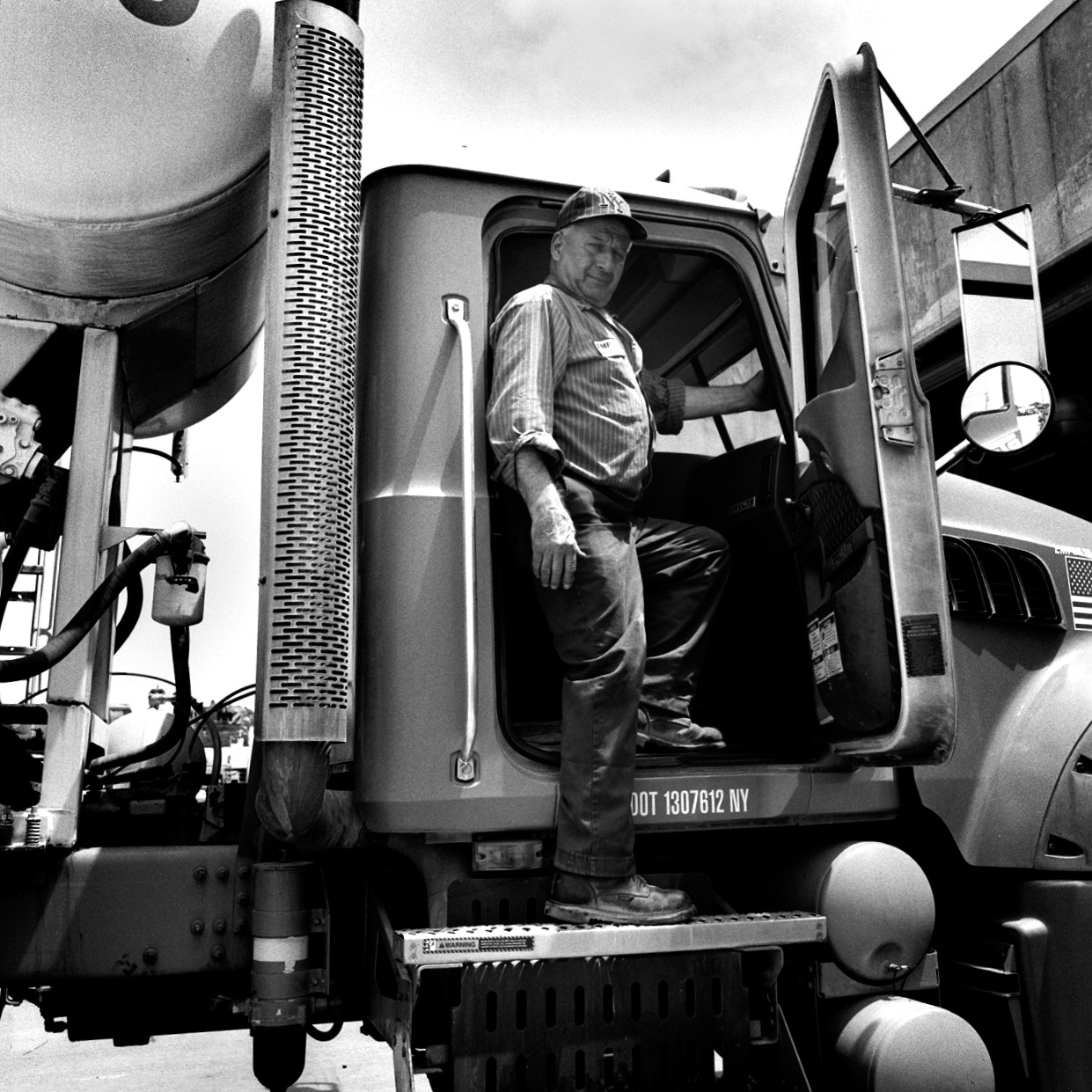  Andrew Kruzzkowski, standing in one of the trucks he has helped maintain as a mechanic for Empire Cement for over 35 years since coming to America from Poland.  Williamsburg, Brooklyn, NY (July 2016) 