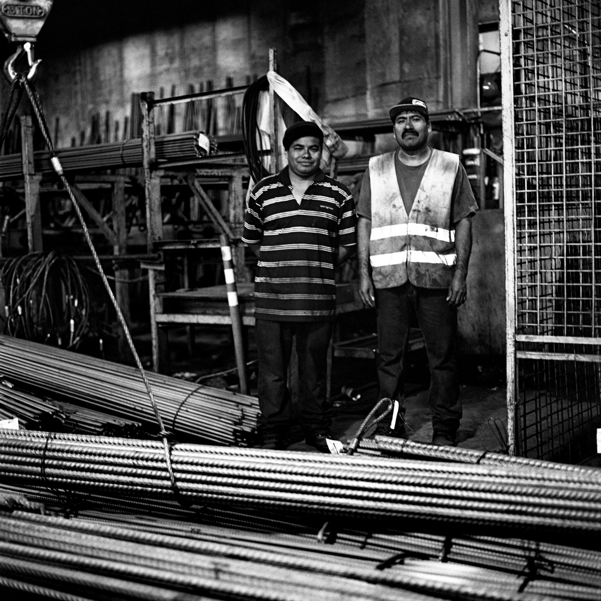  Coworkers inside a rebar fabrication plant with several thousand pounds of rebar awaiting to be manipulated into different shapes and designs for construction projects.  Williamsburg, Brooklyn, N.Y. (Oct. 2015) 