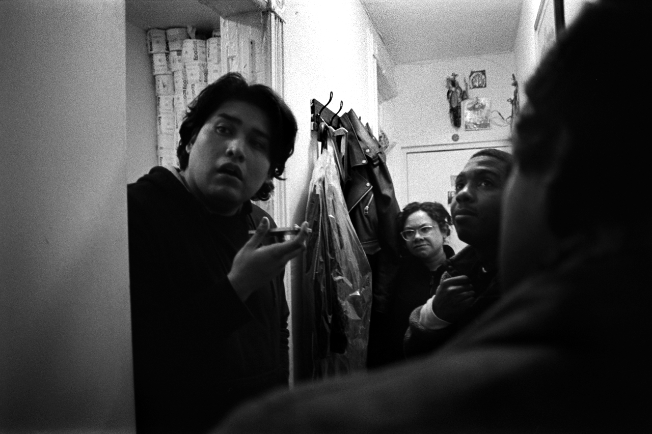  Tenant Roy Cano, on the phone with his super, as Urban Justice Center lawyers and tenant organizer Emmanuel Pardilla listen in on the phone call filled with berating comments over his request to have his apartment's leaks fixed. Mott Haven, Bronx, N