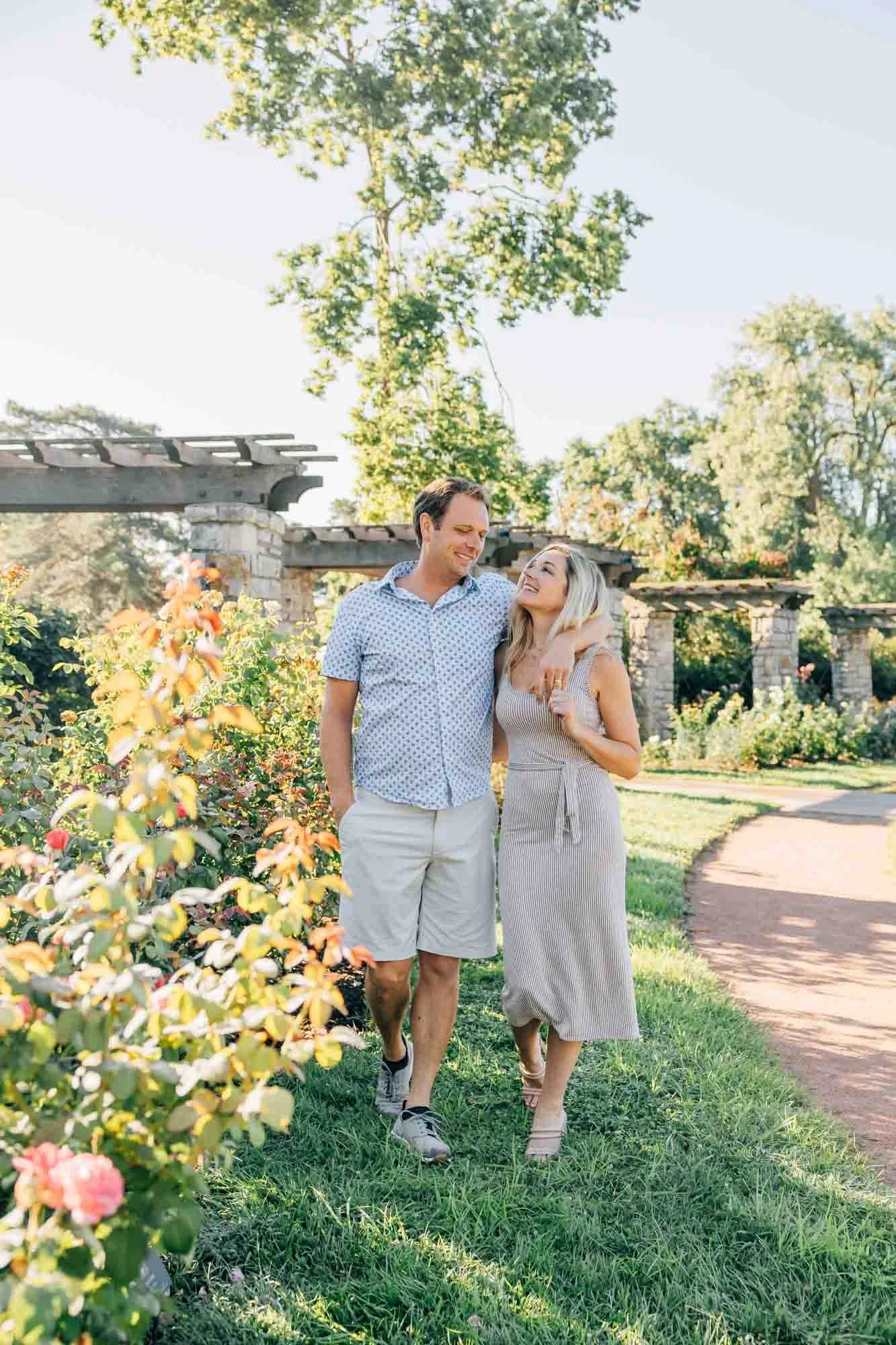 couple laughing together while walking along a garden path